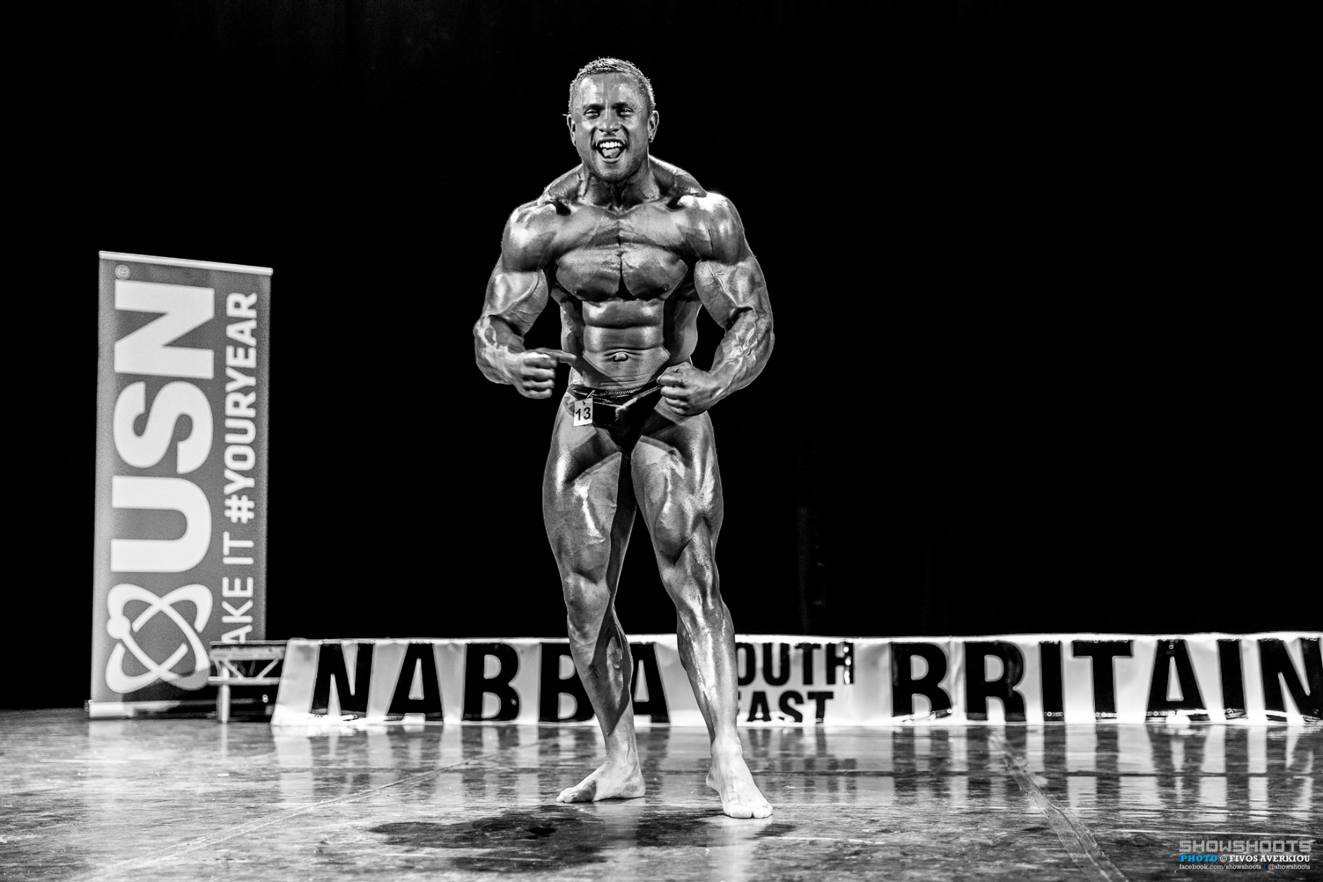 Black and white side chest pose — Domenico Monk on stage